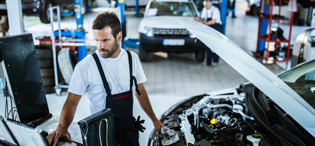 mechanic-diagnosing-car-with-computer Mechanic diagnosing car with computer
