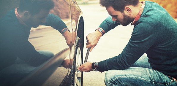 Male-Driver-Removing-Hubcap-From-Tire